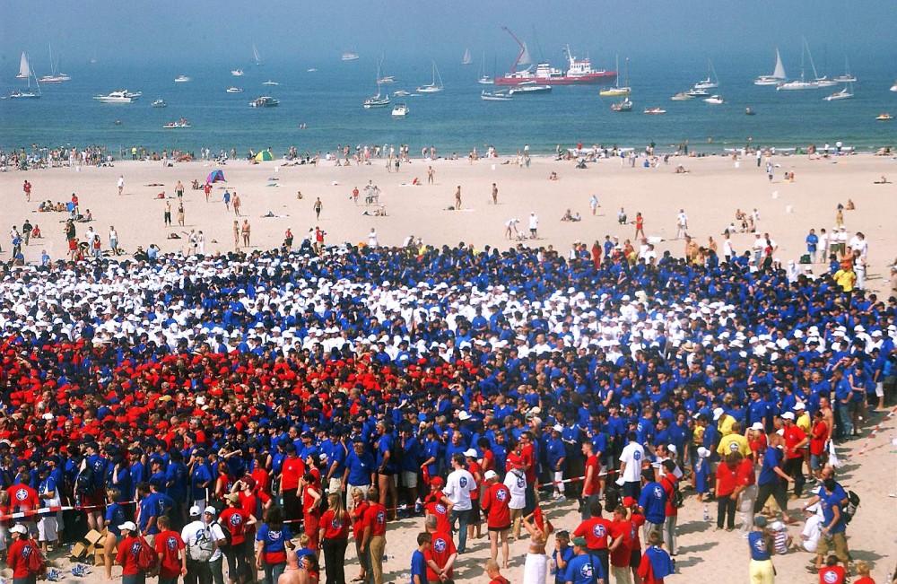 30.000 Menschen bilden 2002 das Logo Ich bin ein Rostock Olymp am Strand von Warnemünde. Foto: Joachim Kloock